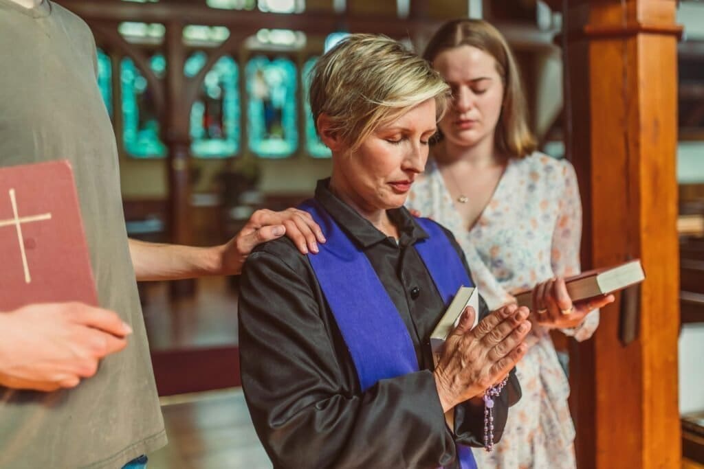 Blonde woman praying at church with friends